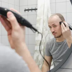 Mężczyzna goli głowę na łyso, używając najlepszej maszynki do golenia.