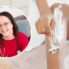 Lekarka w czerwonej bluzce i okularach uśmiecha się, podczas gdy kobieta goli nogi. Wizyta u ginekologa i depilacja - przygotowania do badań.